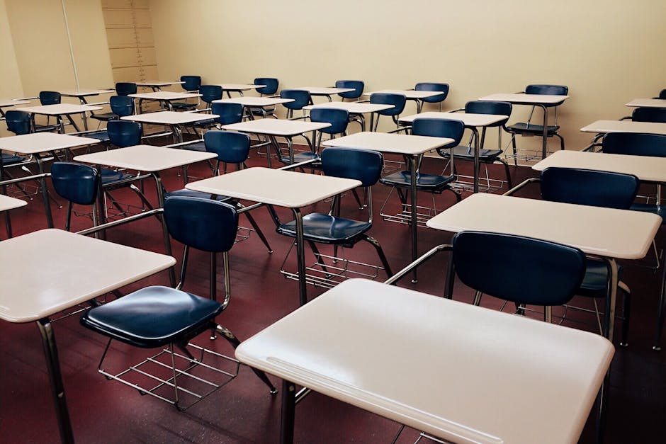 An empty classroom featuring neatly arranged desks and chairs ready for use