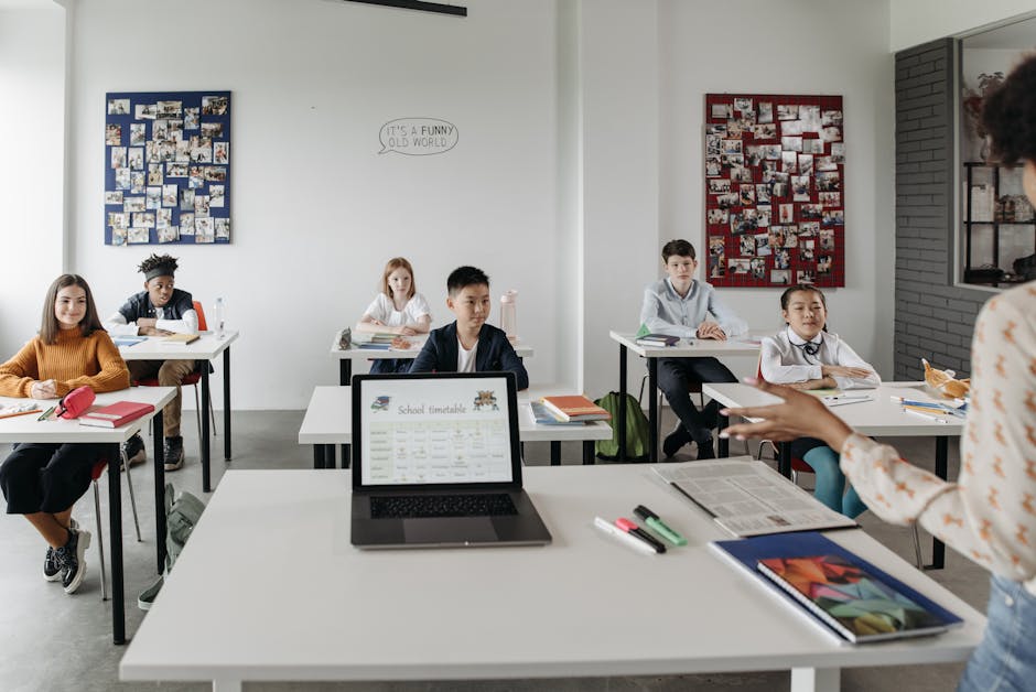 Students in a modern classroom learn with technology under teacher's guidance