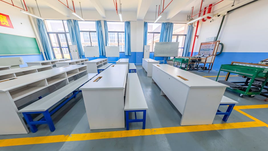 Spacious modern classroom with white desks, blue benches, and bright lighting